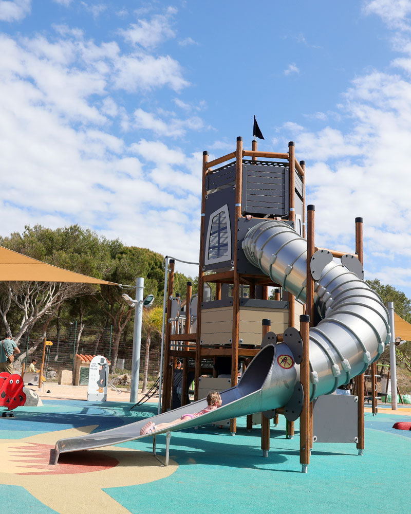 Großes UniPlay Spielanlage  mit einer Röhrenrutsche auf einem Spielplatz mit hellem Belag.